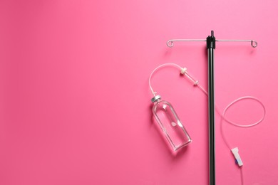 Photo of IV infusion set on pink background, flat lay. Space for text