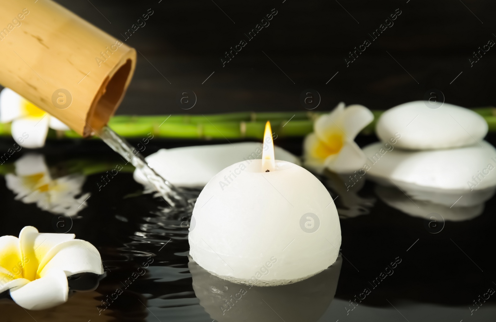 Photo of Spa composition with burning candle in water