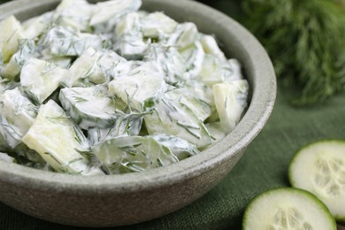 Photo of Delicious cucumber salad in bowl on table, closeup