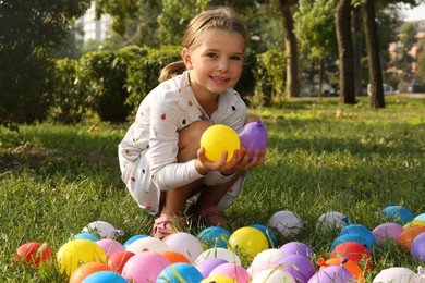 Little girl with water bombs in park