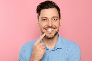 Photo of Smiling man with perfect teeth on color background