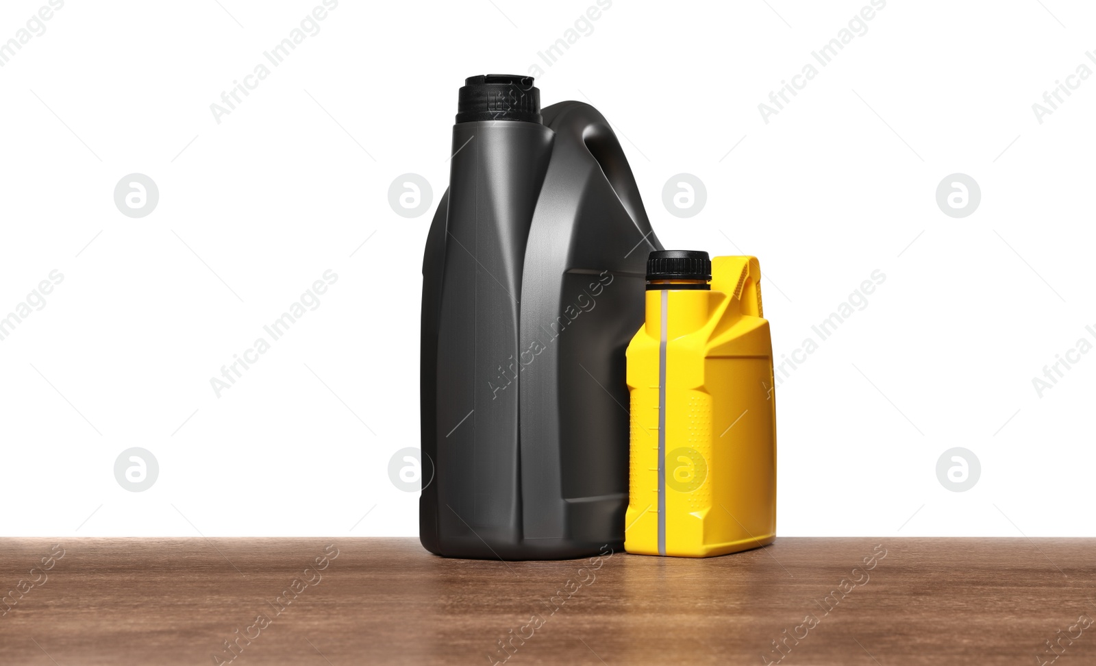 Photo of Motor oil in different containers on wooden table against white background