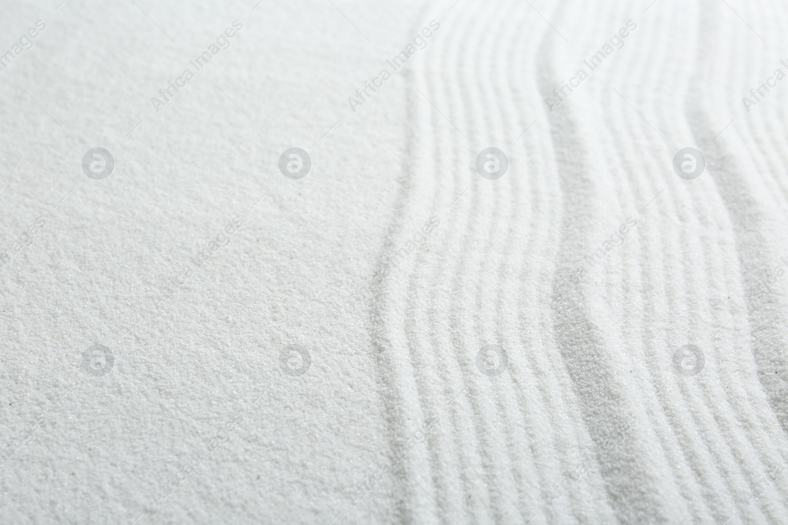 Photo of Zen rock garden. Wave pattern on white sand, closeup. Space for text