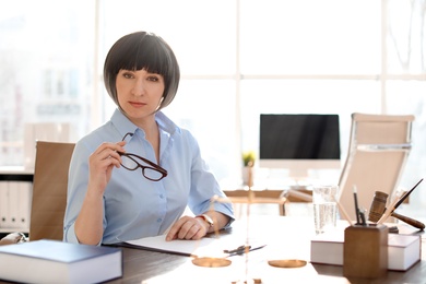 Photo of Female lawyer working at table in office