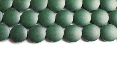 Photo of Spirulina tablets on white background, top view