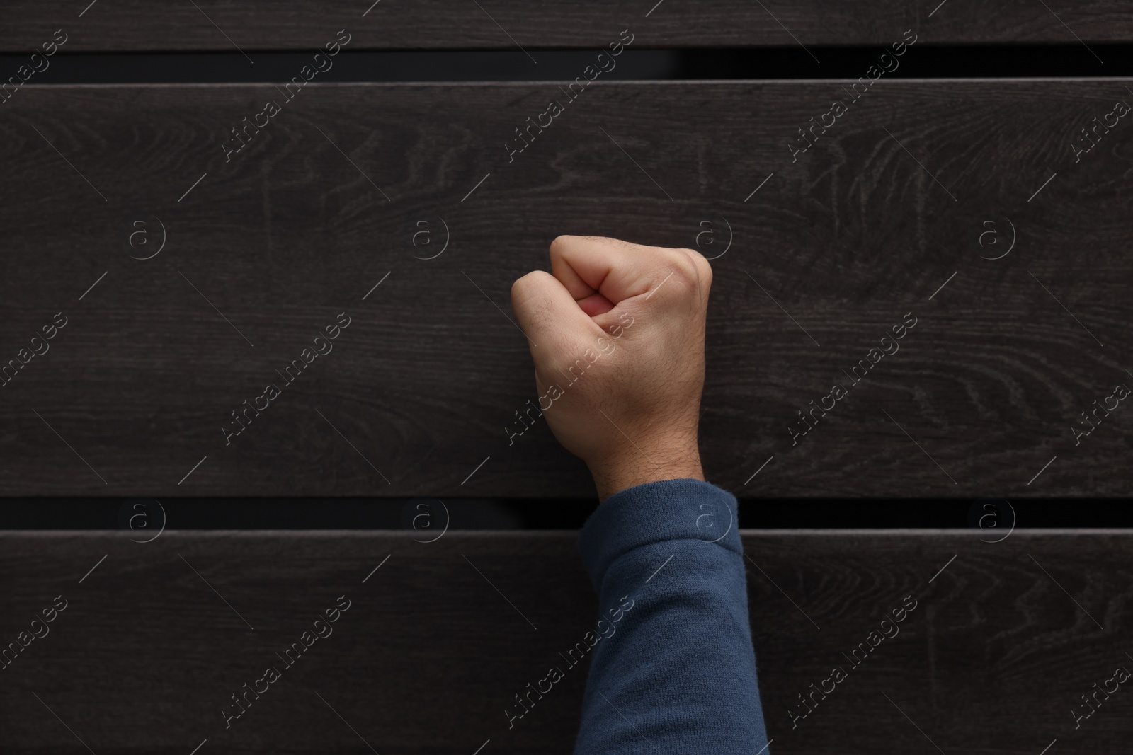 Photo of Collection agent knocking on wooden door, closeup