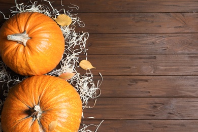 Photo of Flat lay composition with pumpkins and space for text on wooden background. Autumn holidays