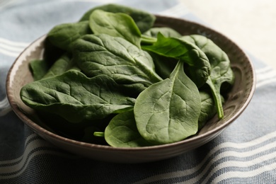 Fresh green healthy spinach leaves in bowl, closeup