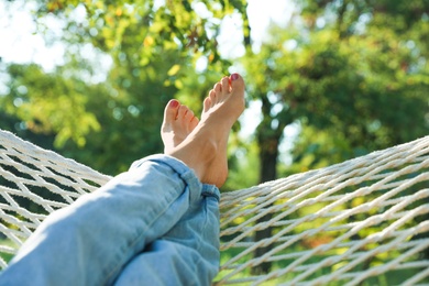 Photo of Young woman resting in comfortable hammock at green garden, closeup