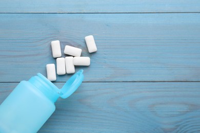 Photo of Jar with chewing gums on light blue wooden table, flat lay. Space for text