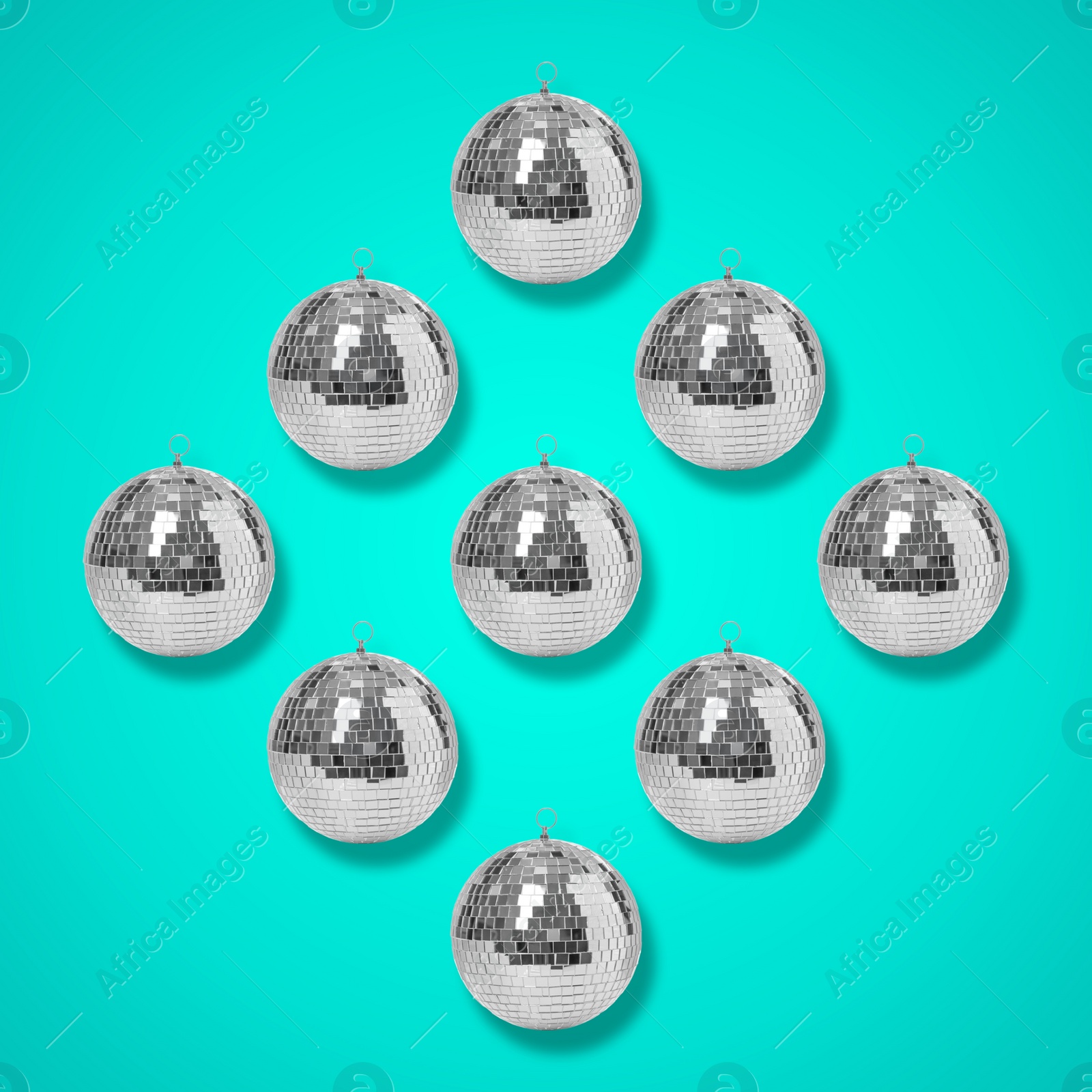 Image of Many shiny disco balls on turquoise background, flat lay