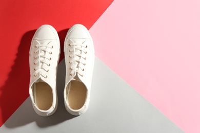 Pair of stylish sneakers on color background, top view with space for text