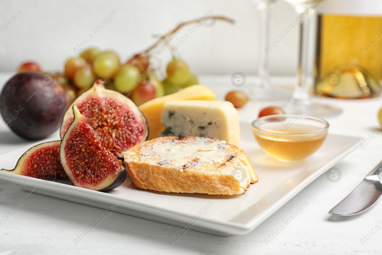 Photo of Ripe figs and slice of bread with butter on plate