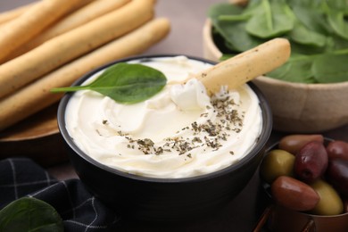 Photo of Delicious cream cheese with grissini stick and spices on table, closeup