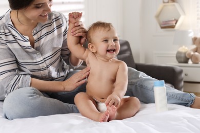 Photo of Mother applying dusting powder on her cute baby at home