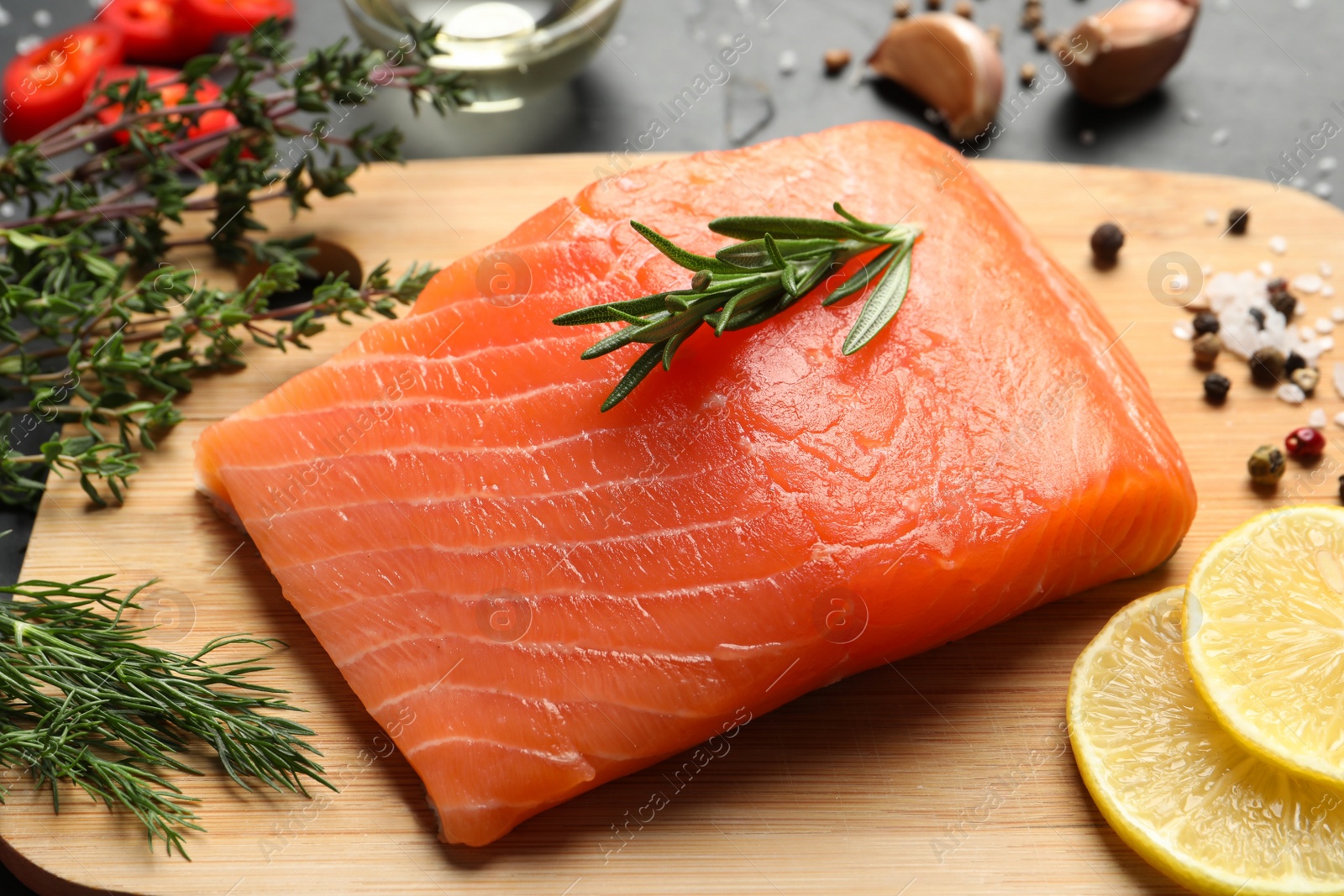 Photo of Fresh raw salmon and ingredients for marinade on black table, closeup