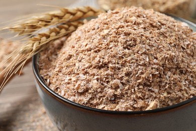 Photo of Wheat bran and spikelets in bowl, closeup