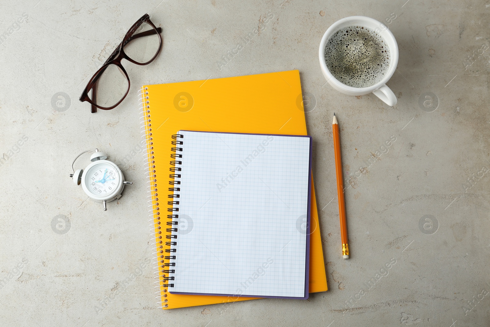 Photo of Flat lay composition with office stationery and cup of coffee on light stone background. Space for design