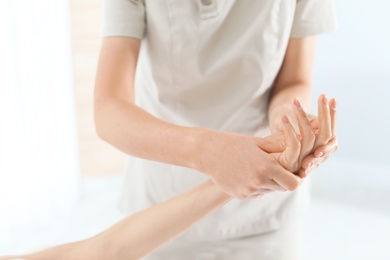 Woman receiving hand massage in wellness center, closeup