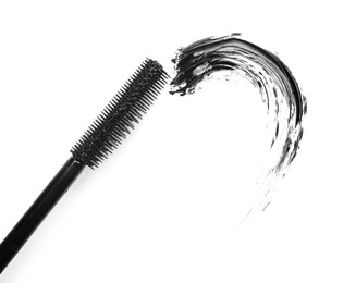 Photo of Smear of black mascara and applicator isolated on white, top view