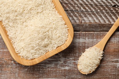 Photo of Raw basmati rice, plate and spoon on wooden table, top view