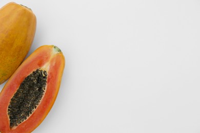 Fresh ripe papaya fruits on white background, flat lay. Space for text