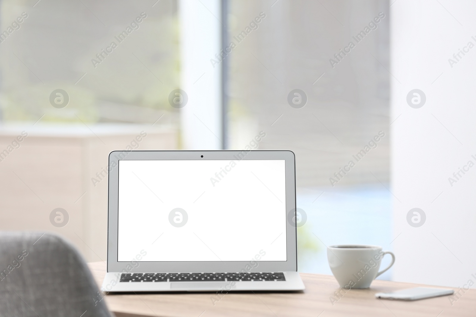 Photo of Modern laptop on desk in room. Home workplace