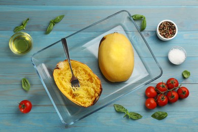 Photo of Cooked spaghetti squashes in baking dish and ingredients on turquoise wooden table, flat lay