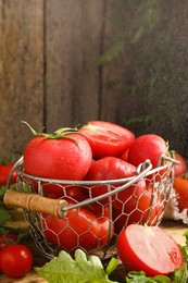 Photo of Fresh ripe tomatoes in metal basket on table. Space for text