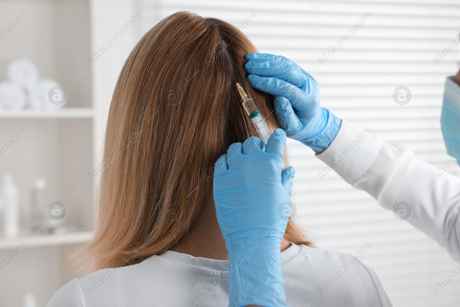 Photo of Trichologist giving injection to patient in clinic, closeup