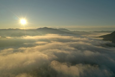 Sun shining over misty mountains. Drone photography	