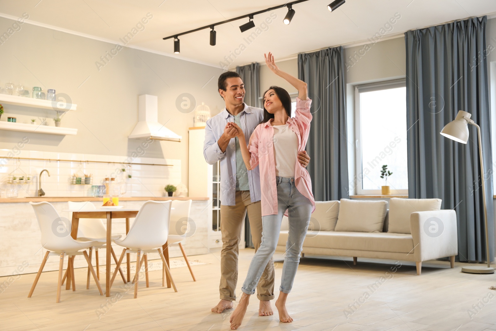 Photo of Lovely young interracial couple dancing at home