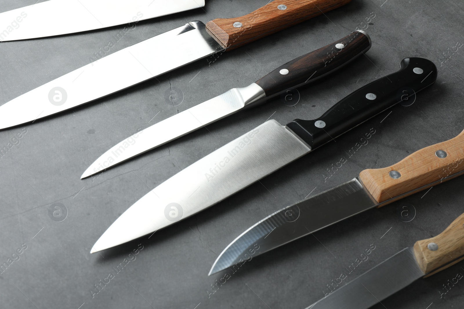 Photo of Many different knives on grey textured table