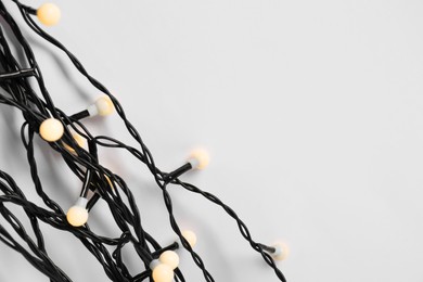 Photo of Beautiful Christmas lights on white background, top view