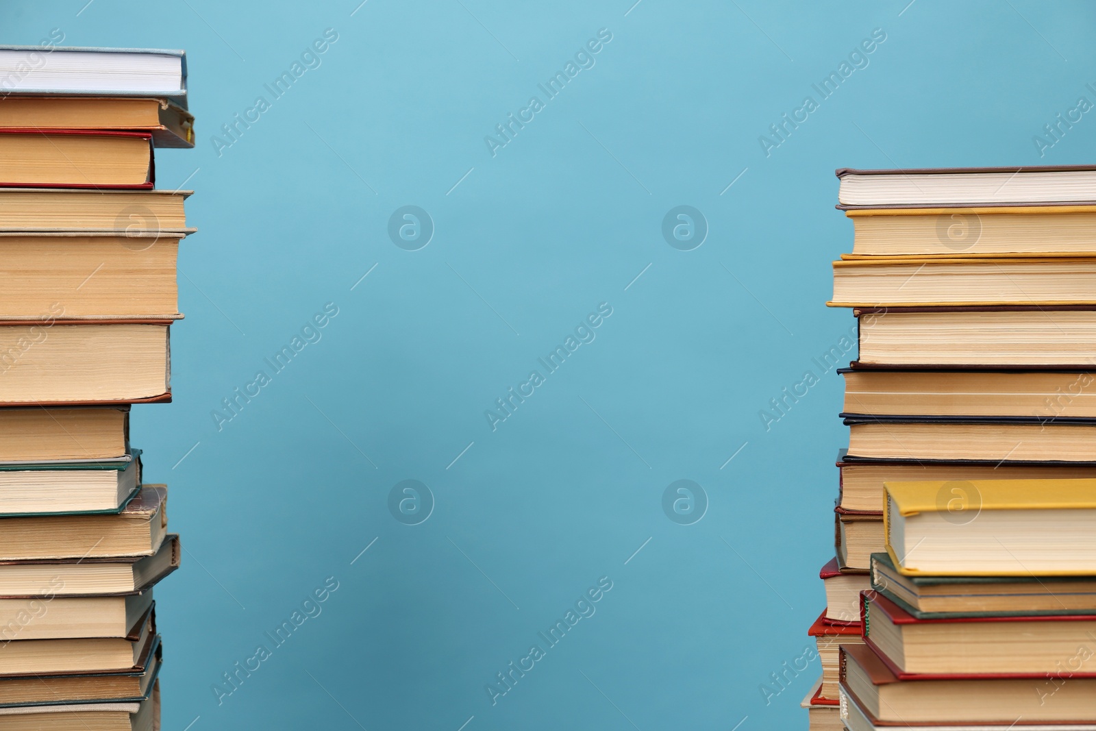 Photo of Many hardcover books on turquoise background, space for text. Library material