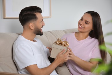 Photo of Lovely couple with beautiful gift at home
