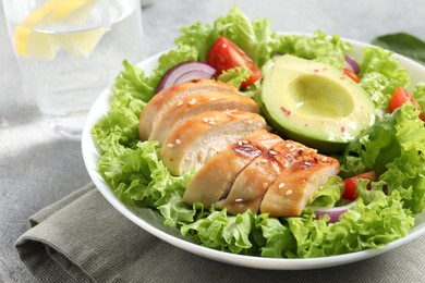 Photo of Delicious salad with chicken, avocado and vegetables on table, closeup