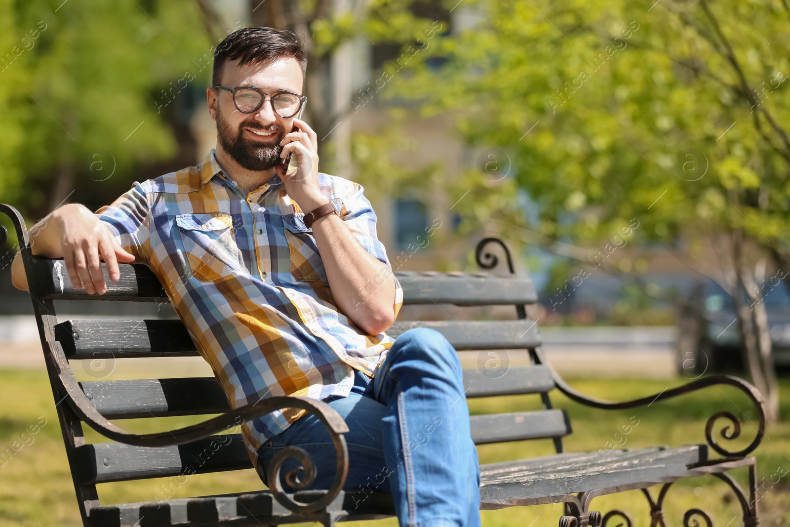 Photo of Portrait of young man talking on phone in park