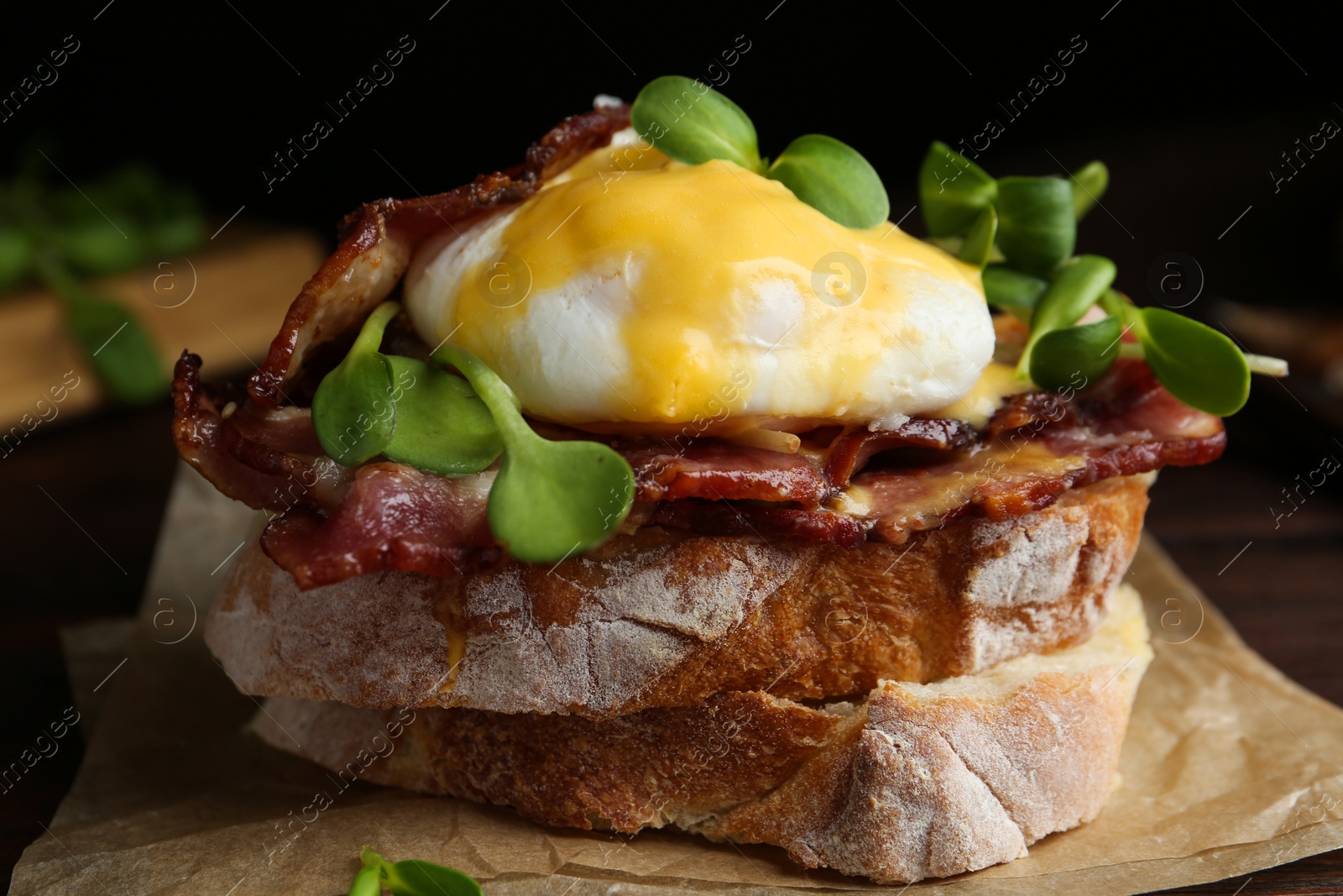 Photo of Delicious egg Benedict served on parchment, closeup
