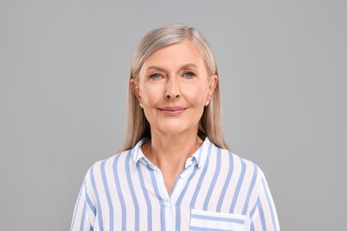 Photo of Portrait of beautiful middle aged woman on light grey background