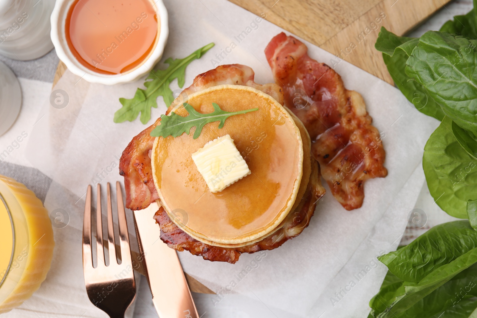 Photo of Delicious pancakes with bacon served on table, flat lay