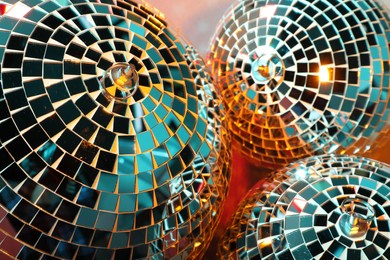 Bright shiny disco balls on color background, closeup