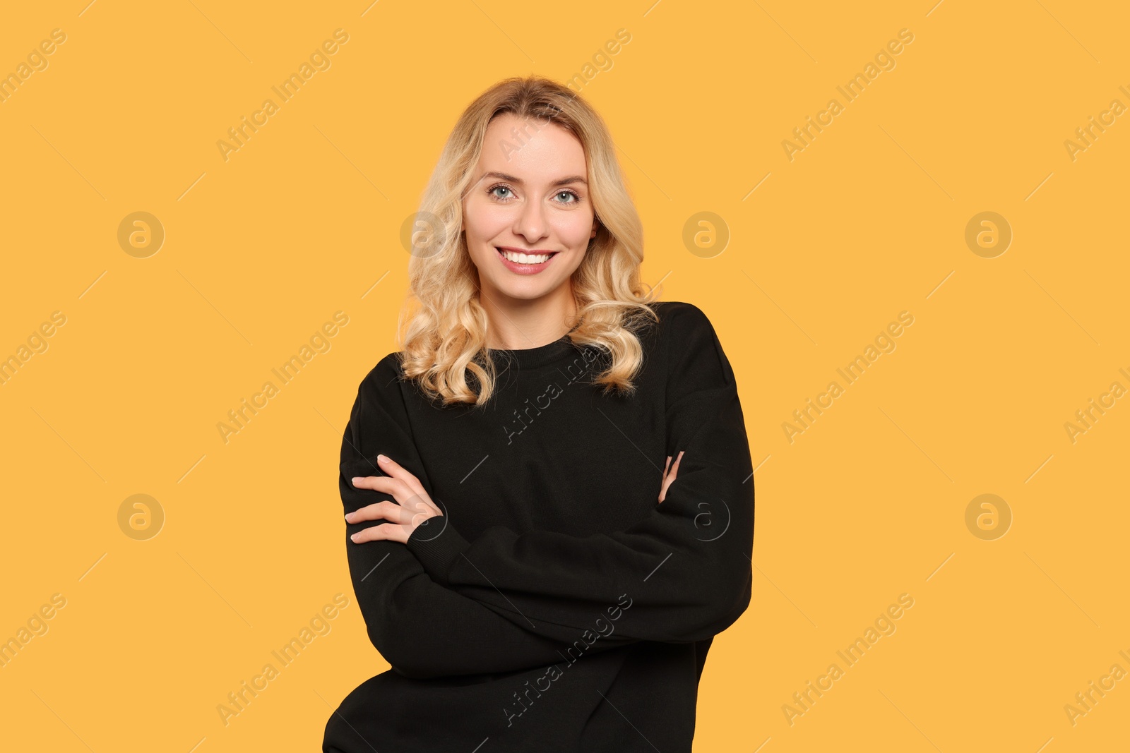 Photo of Happy woman in stylish warm sweater on orange background