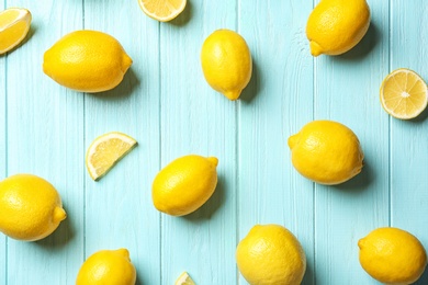 Flat lay composition with whole and sliced lemons on color background