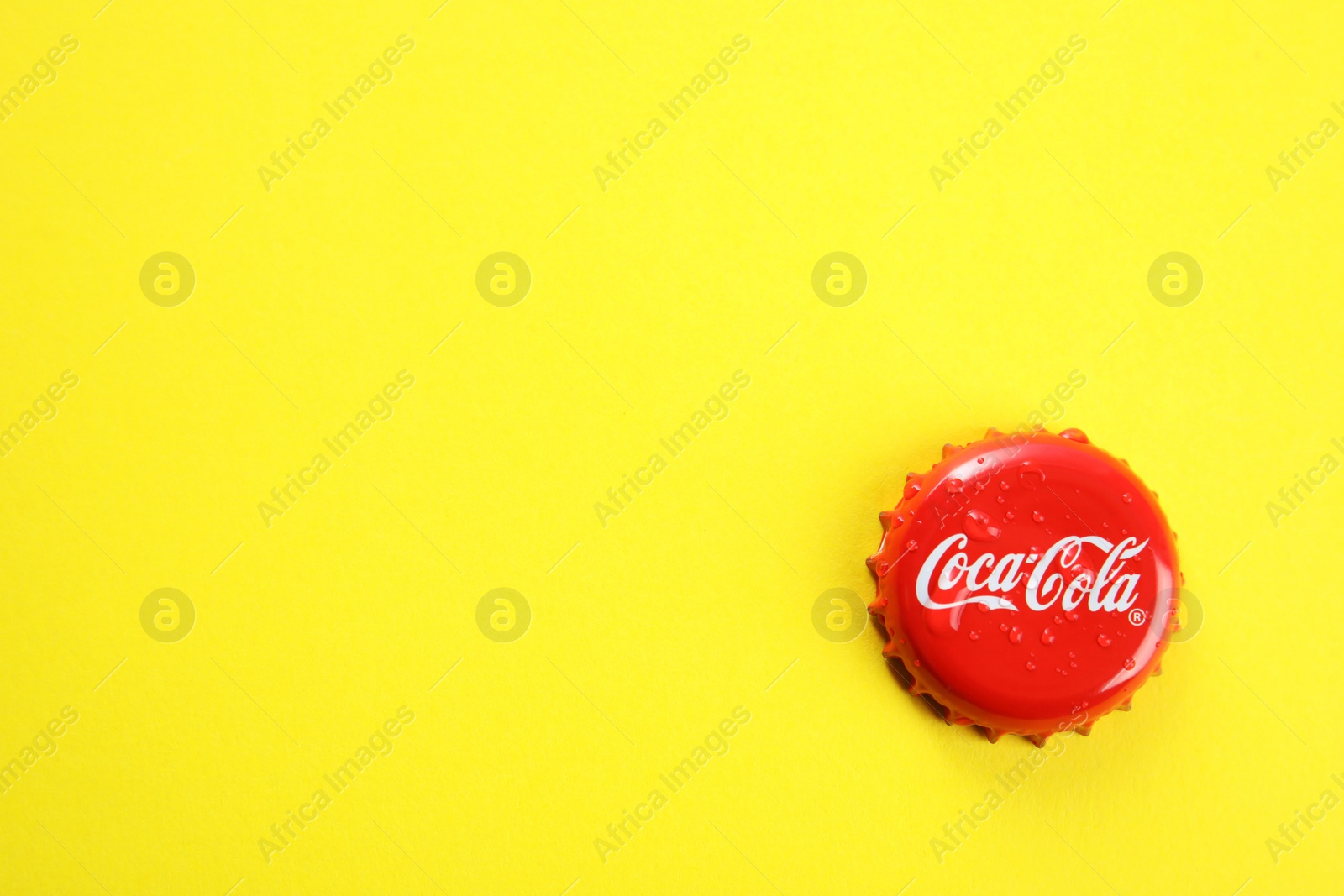 Photo of MYKOLAIV, UKRAINE - NOVEMBER 15, 2018: Coca Cola lid on color background, top view. Space for text