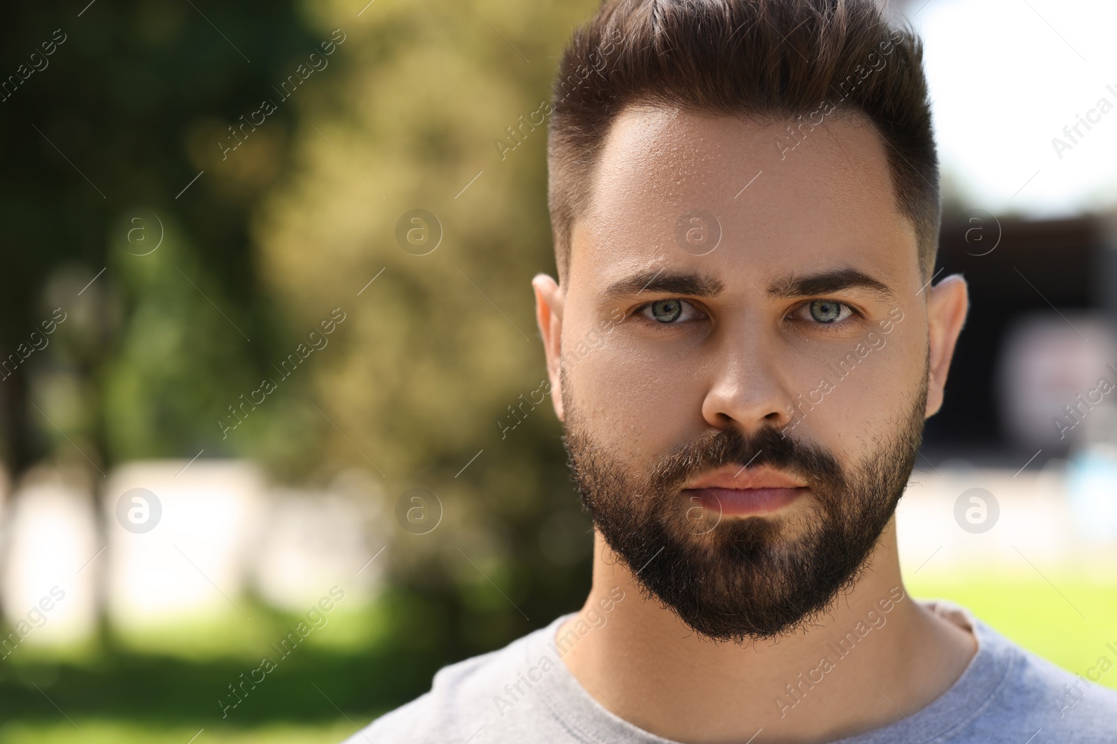Photo of Portrait of young man outdoors on sunny day, closeup. Space for text