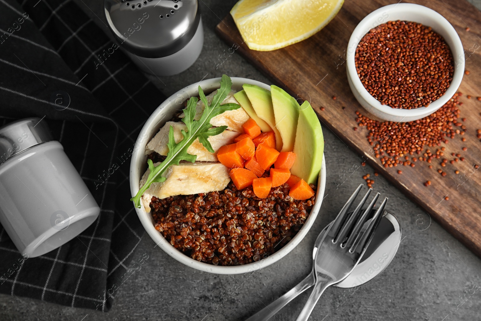 Photo of Red quinoa with garnish in bowl on table, top view