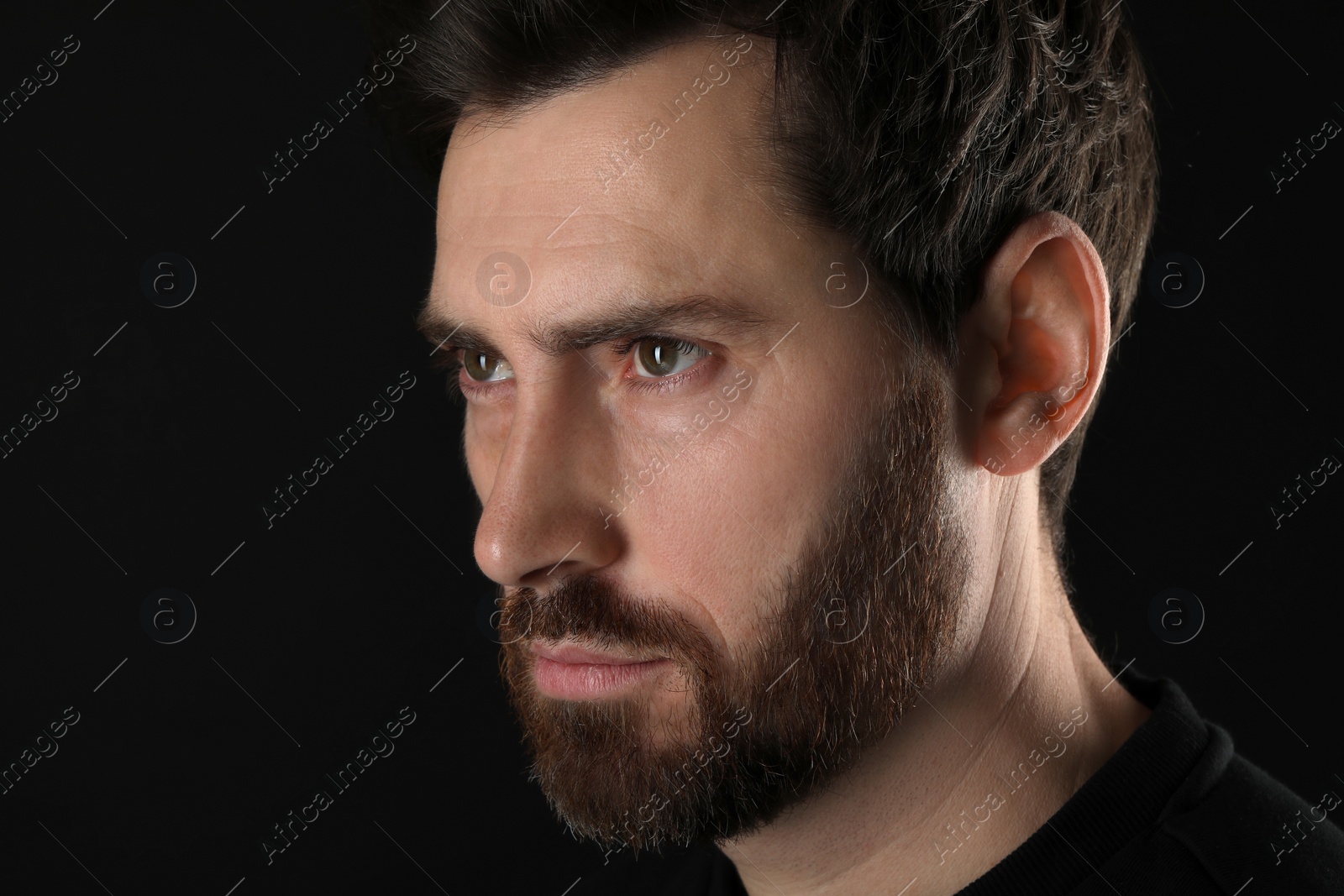 Photo of Evil eye. Man with scary eyes on black background, closeup