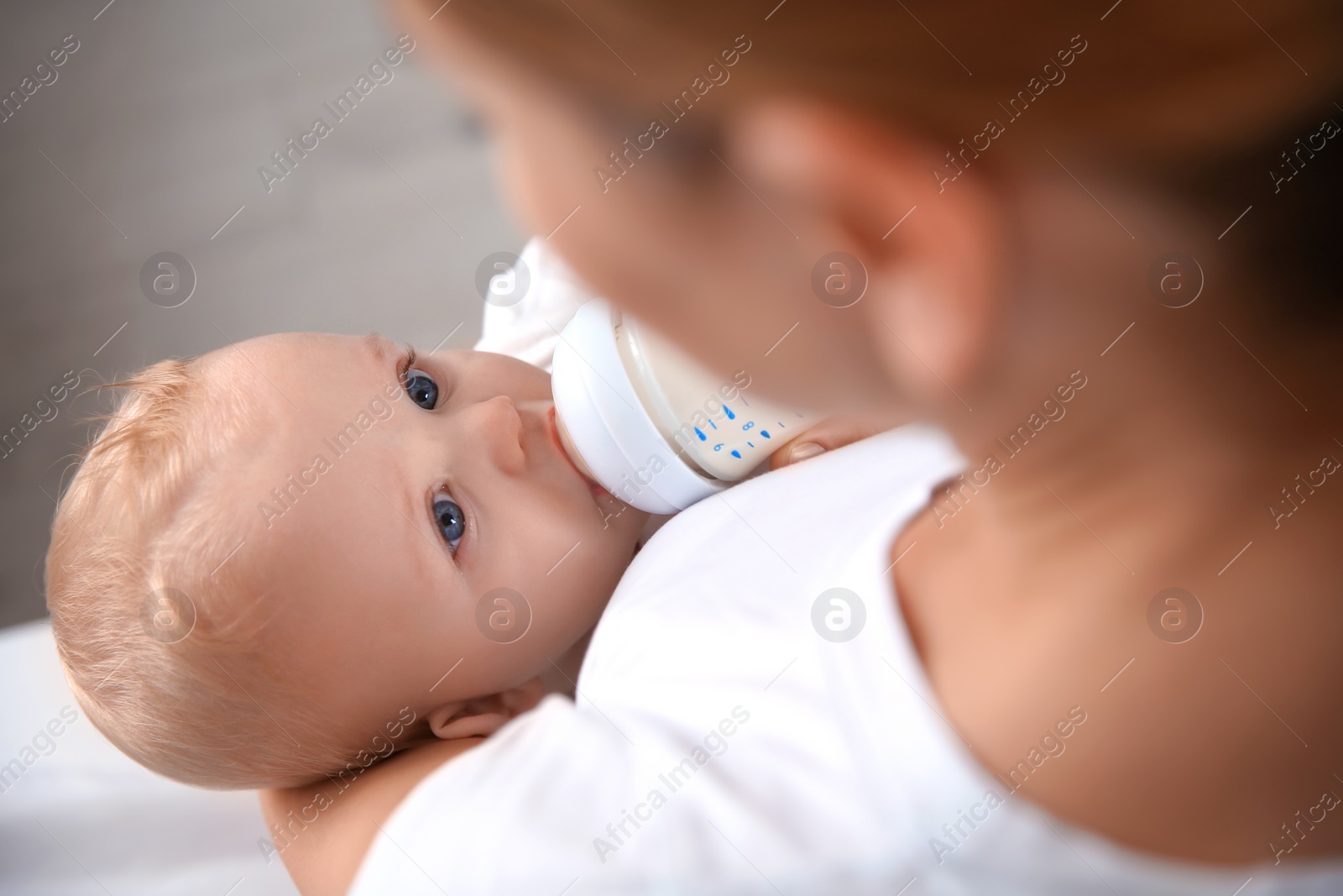 Photo of Lovely mother feeding her baby from bottle, closeup