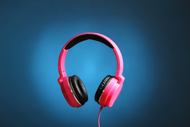 Stylish headphones with pads on color background